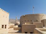 Fort Nizwa Oman, with minaret and dom of mosque in background. 