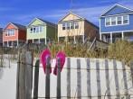 Row of beach rentals on a summer day, pink flip flops on beach fence;  Myrtle Beach, South Carolina